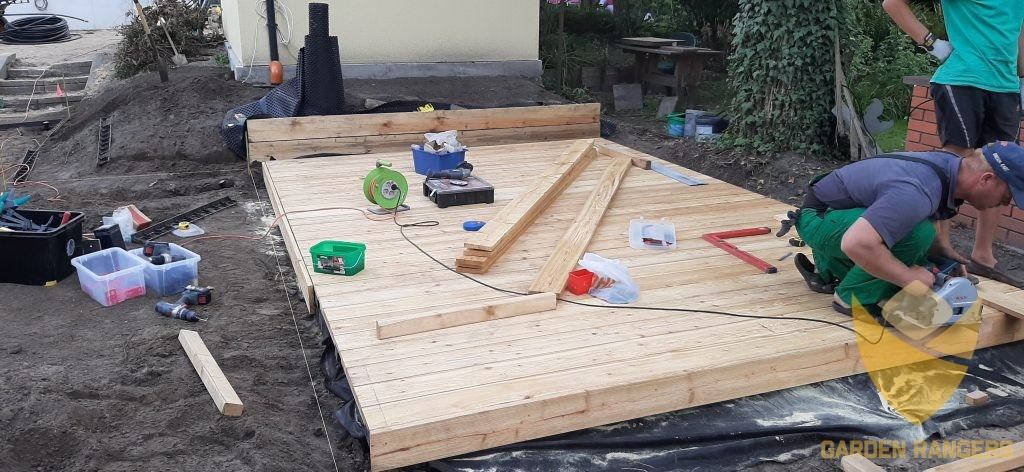 Taras z desek modrzewiowych podczas docinania elementów maskujących boki.